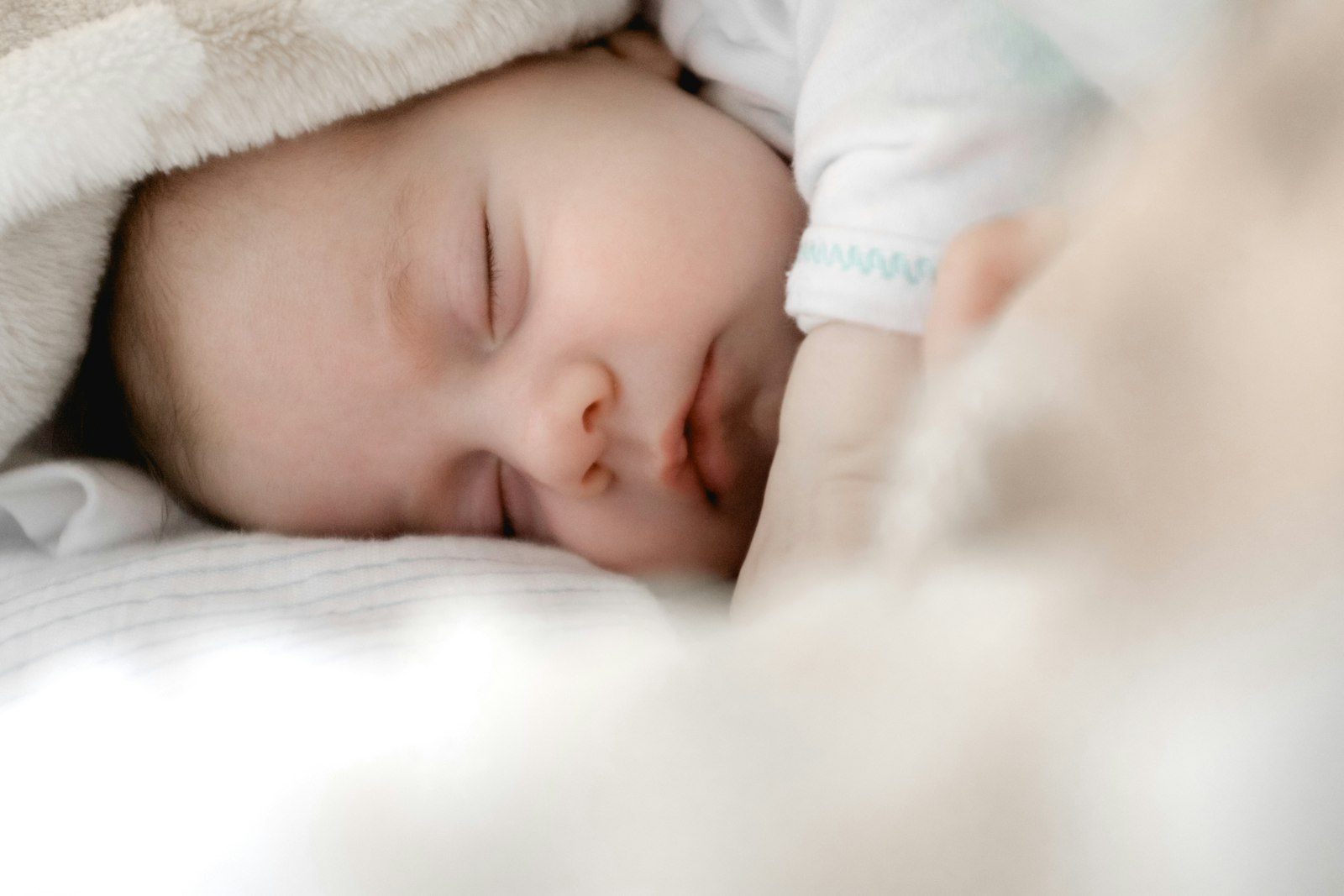 Parent cradling newborn in the first weeks after birth