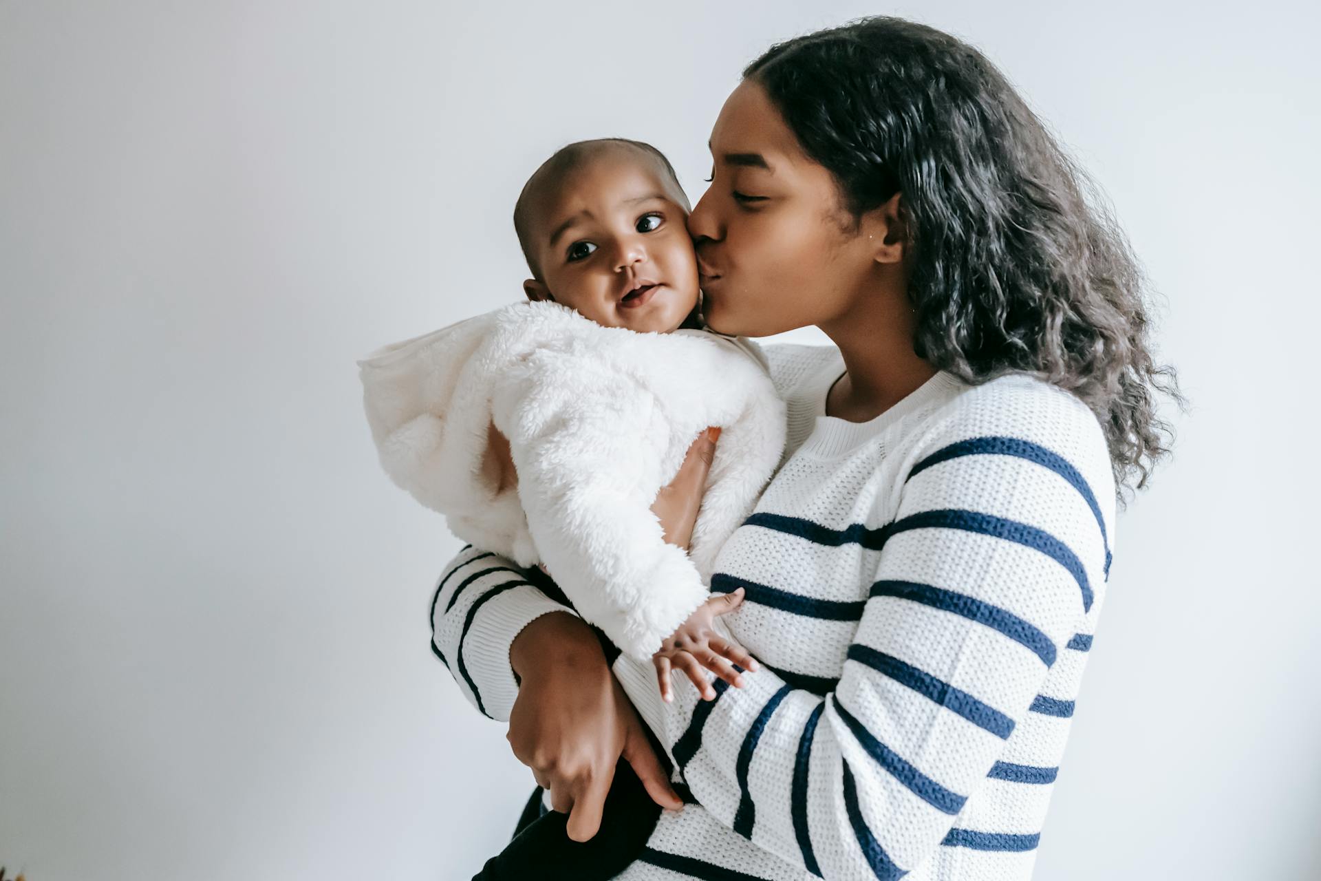 Black mother kissing her adorable baby