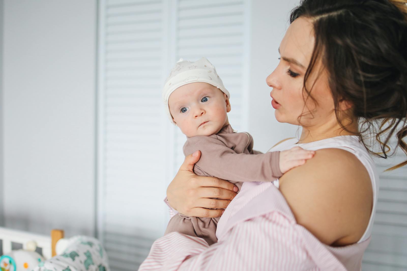 Mother lovingly holding her baby in a warm, supportive setting